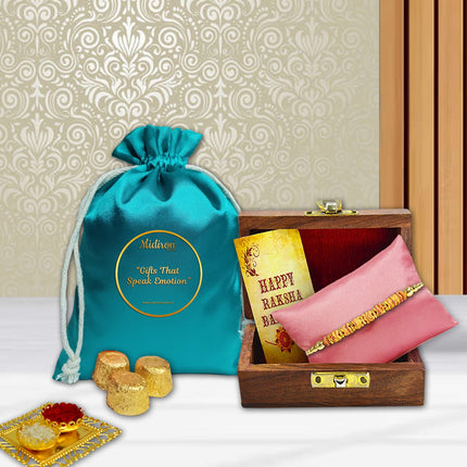 Rakhi gift pack with designer Rakhi in wooden box, indulgent chocolates, roli-chawal containers, and cheerful greeting card.