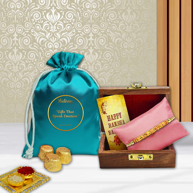Rakhi gift pack with designer Rakhi in wooden box, indulgent chocolates, roli-chawal containers, and cheerful greeting card.