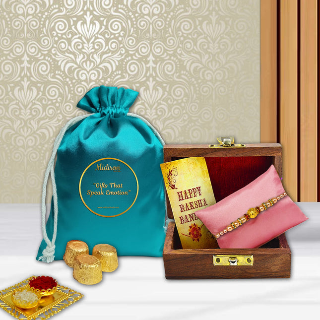 Elegant Rakhi gift pack with handcrafted Rakhi, wooden presentation box, chocolates, festive card, and traditional roli-chawal
