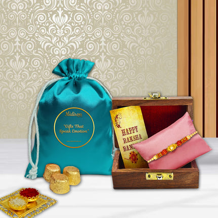 Raksha Bandhan combo with designer Rakhi in wooden box, 90g chocolate pouch, traditional roli-chawal, and greeting card for your brother.