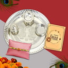 Gracefully designed Raksha Bandhan gift featuring all essentials: silver thali, roli-chawal, and Rakhi with a card.