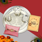 Raksha Bandhan gift honoring tradition — silver-plated pooja thali, roli-chawal, exquisite Rakhi, and a heartwarming note.