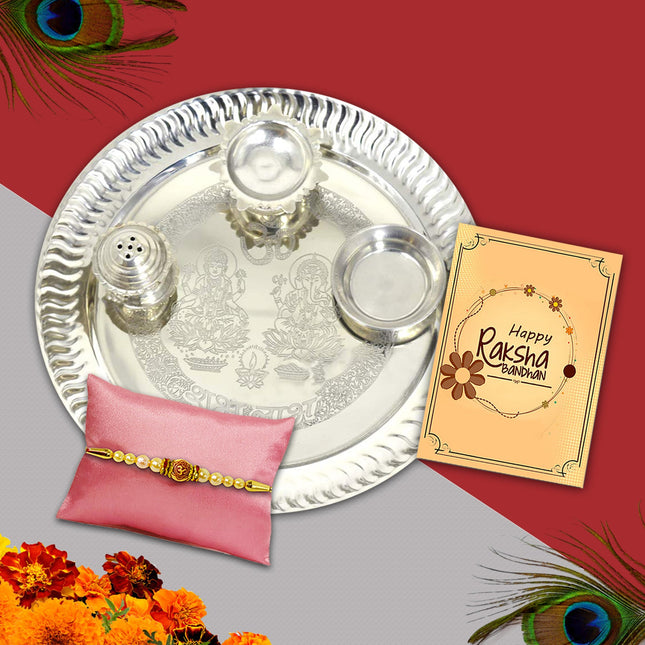 Traditional Raksha Bandhan set with a designer Rakhi, 9-inch silver-plated pooja thali, roli-chawal, and festive greeting card arranged harmoniously