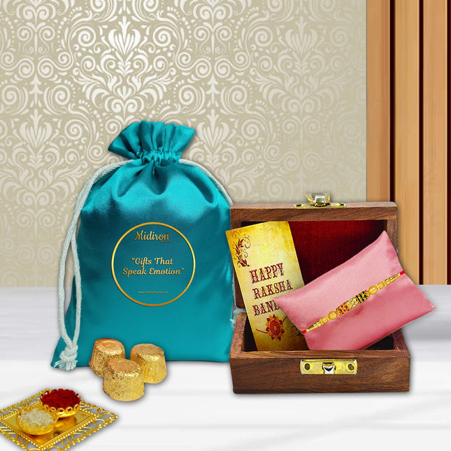 Designer Rakhi in elegant wooden box paired with chocolates, ritual powders, and greeting card — perfect Rakhi offering.