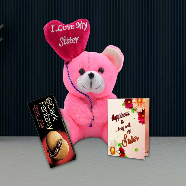 Pink teddy bear with heart-shaped 'I Love My Sister' hat, chocolate bar, and card 
