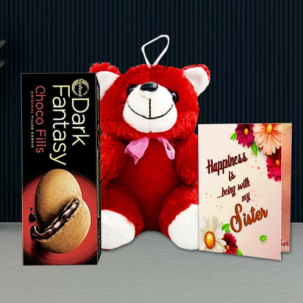 Red teddy bear with a pink bow, box of Dark Fantasy Choco Fills, and a card with floral design 